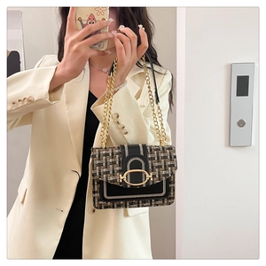 Détail de la texture tissée en tweed avec boucle ovale dorée sur petit sac carré chic