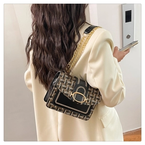 Détail du sac chaîne en tweed et cuir montrant la texture et la boucle dorée