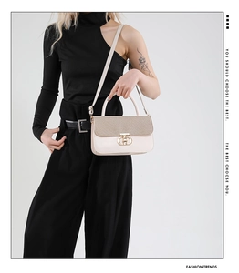 Detailed view of cream-colored shoulder bag with gold sequin flap and D-shape metal lock