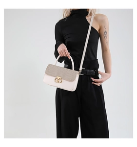 Detail of crossbody handbag featuring beige leather, textured flap, and gold hardware clasp