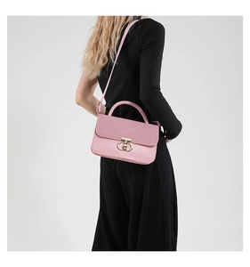 Detailed back view of pink crossbody bag with woven texture flap and golden hardware