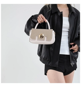 Détail du mélange cuir beige et paille tressée avec boucle métallique dorée