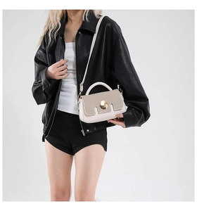 Detail of cream leather crossbody bag with glitter texture and gold metal buckle