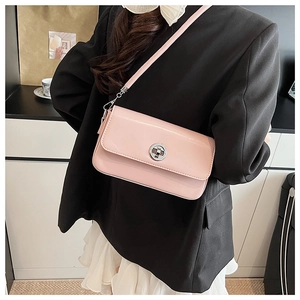Detail of light pink rectangular crossbody bag with silver twist lock and smooth texture