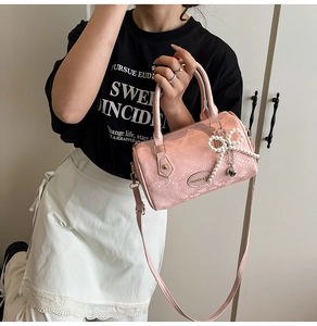 Pink snakeskin pattern Boston bag with pearl bow and heart charm detail