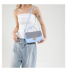 Detail of light blue crossbody bag with silver sequin flap and gold metallic lock