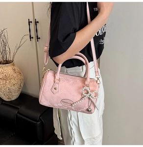 Pink faux snake texture pillow bag with pearl bow charm and adjustable strap