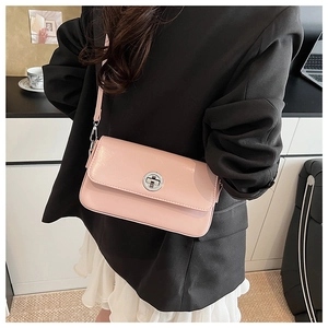 Detail of light pink rectangular shoulder bag with silver clasp worn by model