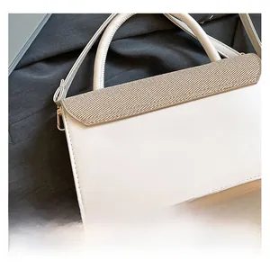 Detail of white PU leather handbag featuring a beige woven texture flap and silver metal hooks