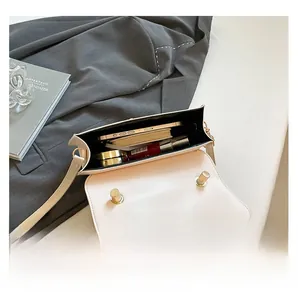 Interior view of off-white leather bag showing phone and makeup storage capacity