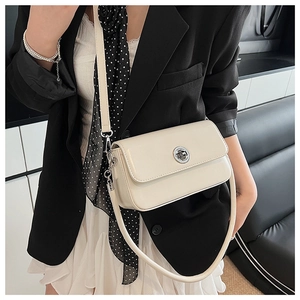 Close-up of a stylish cream-colored mini square crossbody bag with silver twist lock