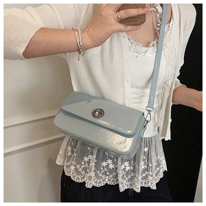 Detail of light blue patent leather bag with silver twist lock and slim shoulder strap