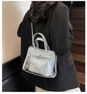 Borsa jelly in PVC azzurro trasparente portata a tracolla da una modella sulle scale