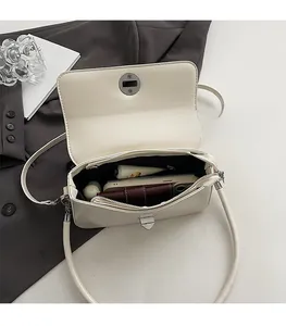 Interior view of cream square crossbody bag showing storage space for phone and lipstick