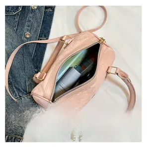 Detail of pink snakeskin cylinder bag interior showing capacity for cosmetics and accessories