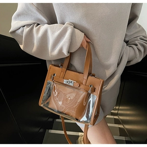 Dettaglio della borsa Kelly in PVC trasparente con finiture in pelle marrone e fibbia