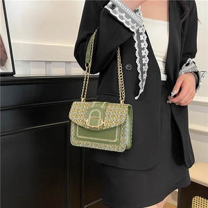 Vintage green woven tweed crossbody bag with gold chain strap shown on a model