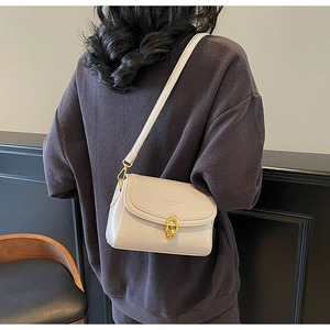 Détail d'un petit sac bandoulière blanc crème en cuir avec fermoir doré élégant