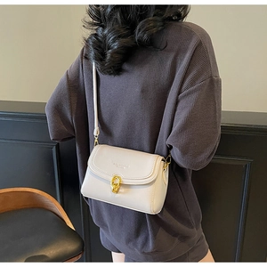 Vue détaillée du sac à bandoulière en cuir PU crème avec un fermoir tournant en forme de cœur
