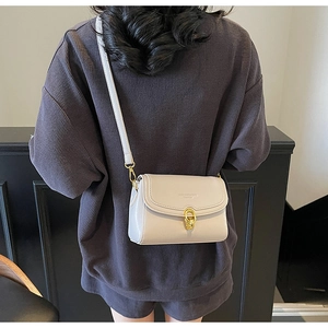 Vue portée d'un sac bandoulière en cuir PU blanc cassé avec fermoir doré à double anneau