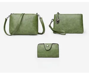 Detailed set of green vintage textured leather handbags with dark metal hardware