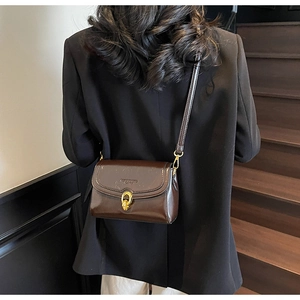 Vue détaillée du sac à bandoulière en cuir PU marron foncé avec boucle dorée et fine lanière