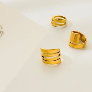 Detailed view of layered spiral 18K gold-plated titanium steel rings with wide-band design