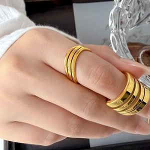 Detailed view of layered gold-plated titanium steel rings with a polished finish