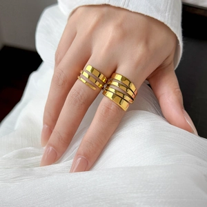 Detail of 18K gold-plated double and multi-layer spiral rings on white fabric