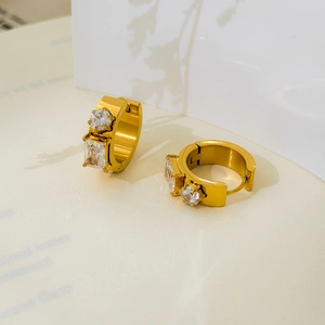 Detail of 18K gold-plated hoop earring with round and square zircon stones on brushed metal