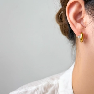 Macro view of 18K gold plated hoop earring with a pear-cut white zircon drop on model