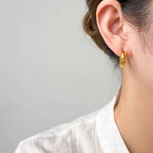 Detail of 18K gold plated hoop earring featuring engraved stars and zircon stone accents