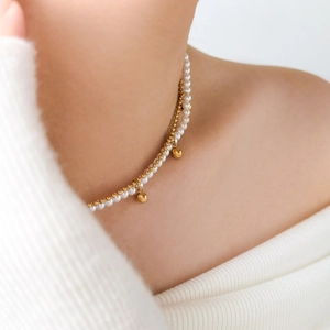 Detail view of double-layer necklace with white pearls and 18K gold-plated beaded chain