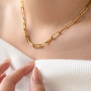 Detail of 18K gold plated oval chain necklace featuring a zircon rectangle link on model