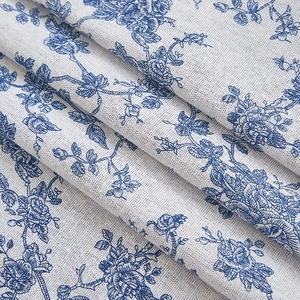 Close-up of retro blue floral cotton linen fabric showing woven texture and drape