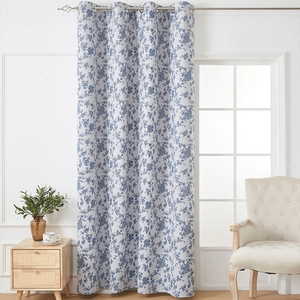 Close-up of blue floral blackout curtain with metal grommets in a cozy living room