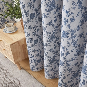 Detail of vintage blue floral linen curtain showing natural drape and fabric texture