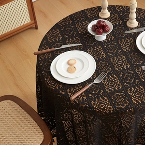 Close-up of black hollow crochet lace tablecloth with detailed geometric floral patterns