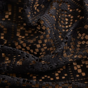 Macro detail of black vintage lace tablecloth with hollow crochet floral patterns