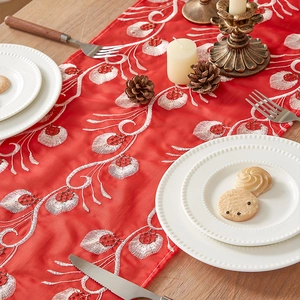 Classical red table runner with golden peacock feather embroidery on wooden dining table