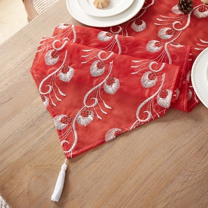 Red Chinese embroidery table runner with white floral patterns and elegant fringe tassels