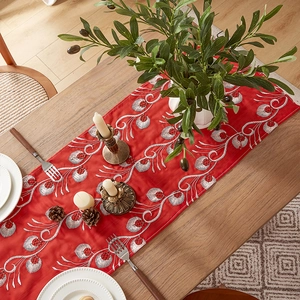 Close-up of red Chinese table runner with peacock feather and flower embroidery