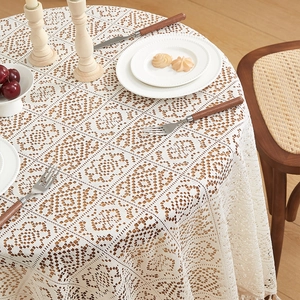 Detailed close-up of beige crochet lace tablecloth with elegant hollow floral pattern
