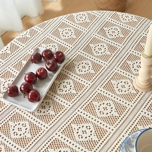 Detail of vintage crochet hollow tablecloth with floral geometric patterns on round table