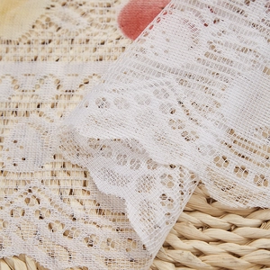 Gros plan détaillé sur le tissu en dentelle tricotée blanche avec un motif floral évidé