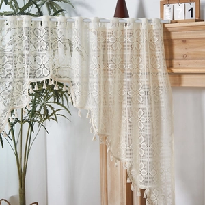 Tenda in pizzo beige con motivi floreali all'uncinetto e frange decorative
