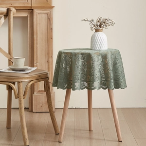 Macro detail of sage green round lace tablecloth with floral embroidery and scalloped edges