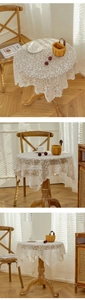 Detail of white lace tablecloth with floral hollow patterns and wavy scalloped edges