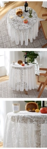 Detailed close-up of white lace tablecloth featuring vintage floral embroidery and mesh texture