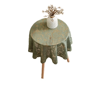 Sage green round lace tablecloth with vintage damask patterns and ruffled edges on white background